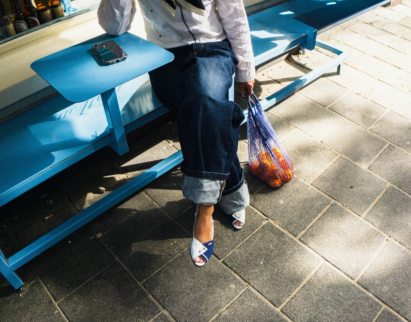 Indigo heels and jeans beside a blue café bench