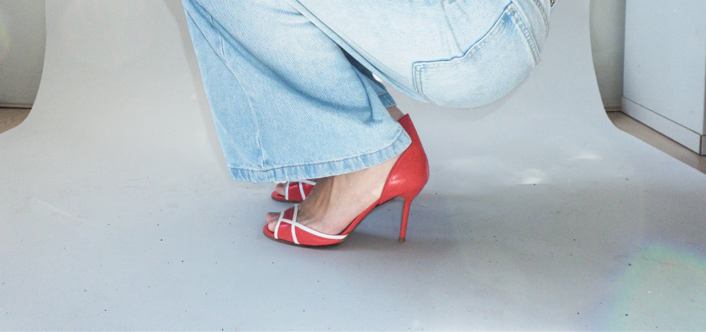 Close-up of red velou heels with jeans